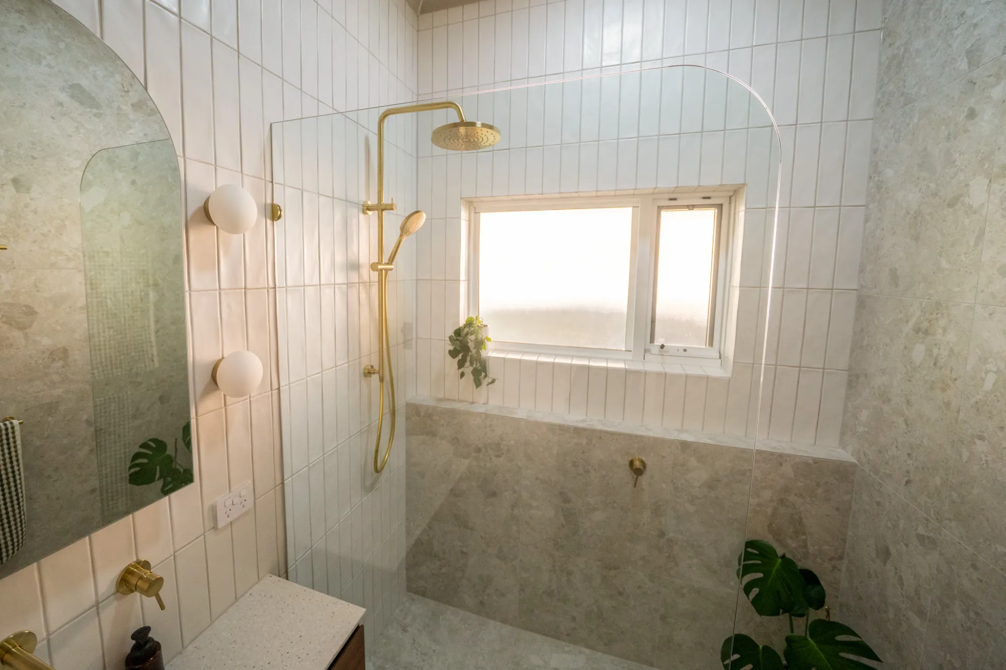 Light bathroom with vertical tiles and gold fixtures
